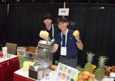 Wataru Ichijo and Ryo Takeshito from Astra showing the mango and pineapple peeled by their peeling machine